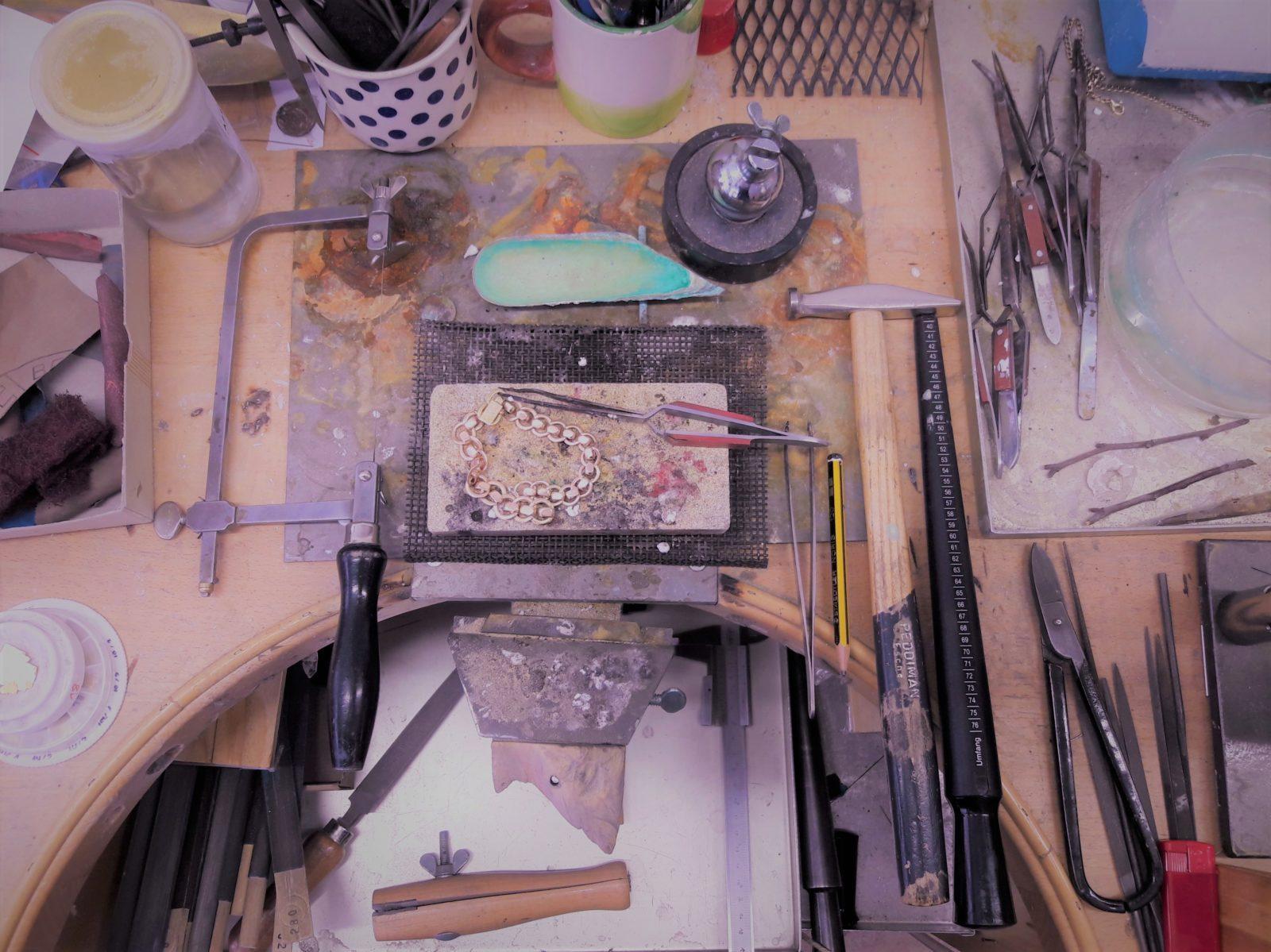 Blick von Oben auf einen Goldschmiede Werktisch mit Werkzeugen für den Trauringkurs Blick von Oben auf einen Goldschmiede Werktisch mit Werkzeugen für den Trauringkurs