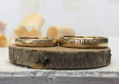 Gelbe geschmiedete Eheringe zwei verschiedene Oberflächen Mustermix Baumrinde Federblattmix