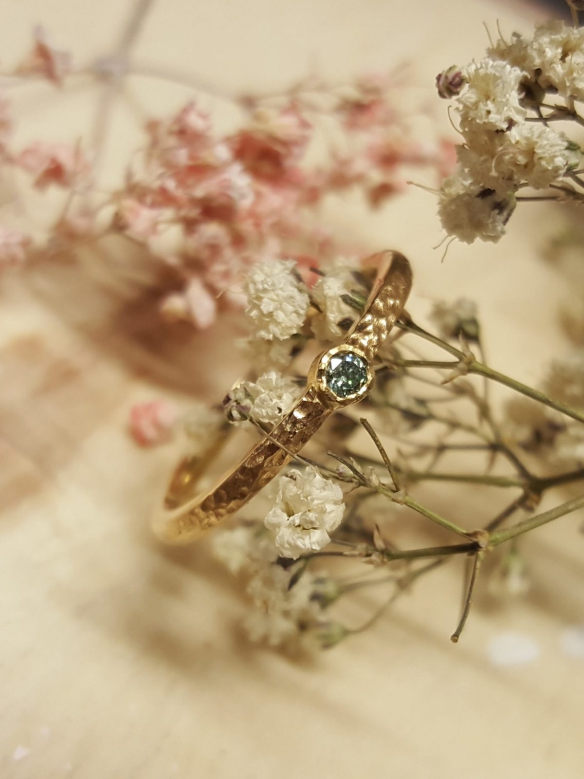 Verlobungsring in mattem Gelbgold mit weißem großen Brillanten.